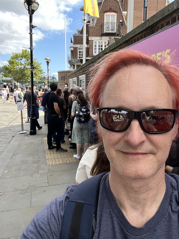 On the queue with the other Groundlings.